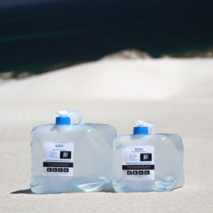 2 filled collapsible water containers on the beach
