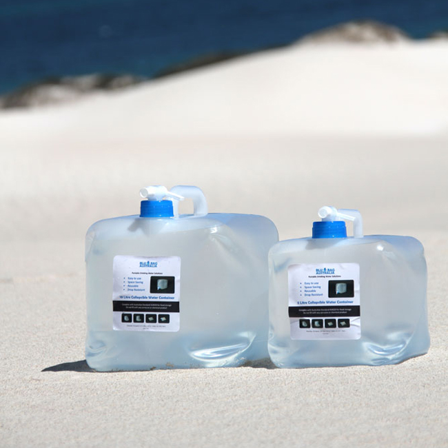 2 collapsible water containers filled with water and sitting on the beach